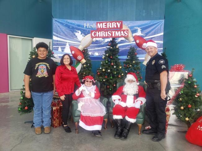 Supervisor Karen Spiegel and grandson with Santa and Mrs. Clause and a Corona Police Officer